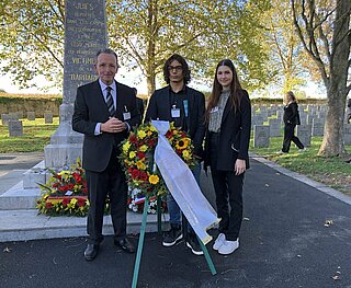 Gedenken: BM Käuflein mit den Jugendlichen Emanuel Ünal und Jessica Pieth bei der Kranzniederlegung auf dem Friedhof in Gurs.