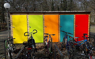 Das Bild zeigt den Spielgeräteschrank im Hof der Eichendorffschule mit Fahrrädern im Vordergrund.