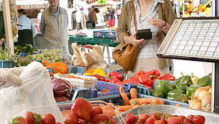 Das Bild zeigt einen Marktstand mit Obst und Gemüse auf dem Wochenmarkt Stephanplatz