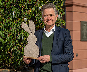 Oberbürgermeister Dr. Mentrup hält einen Hasen aus Filz in der Hand