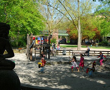 Das Bild zeigt spielende Kinder auf dem Spielplatz am Sonntagplatz.