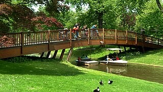 Das Bild zeigt eine Brücke über dem Stadtgartensee mit Gondoletta im Zoologischen Stadtgarten.