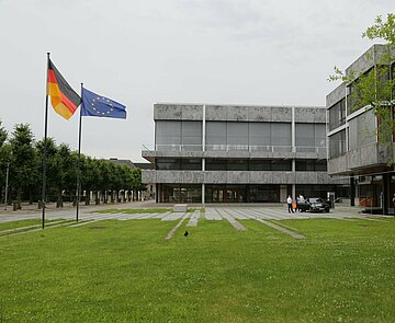 Das Bundesverfassungsgericht mit der Europa- und der Deutschlandflagge im Vordergrund.