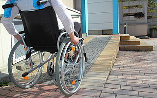 Person im Rollstuhl fährt Rampe hinauf