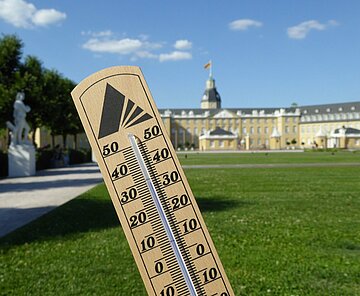 Ein Thermometer zeigt über 30 Grad Celsius vor dem Karlruher Schloss an.