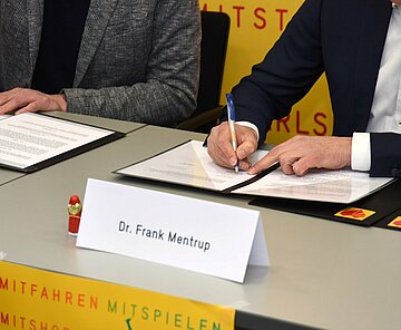 Oberbürgermeister Mentrup unterschreibt einen Beitrittsvertrag zur Sozialregion Karlsruhe.