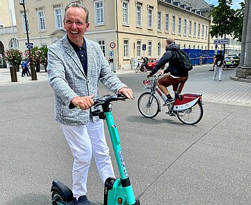 Bürgermeister Dr. Albert Käuflein fährt E-Roller.