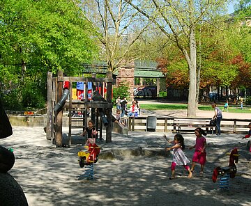 Das Bild zeigt spielende Kinder auf dem Spielplatz am Sonntagplatz.