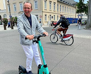 Bürgermeister Dr. Albert Käuflein fährt E-Roller.