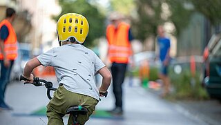 Kind fährt auf Straße mit Fahrrad