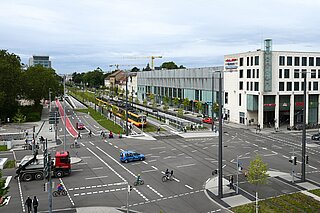 Radverkehr an der Kreuzung am Ettlinger Tor. Außerdem sind Fußgänger, Autos und LKWs auf der Straße.