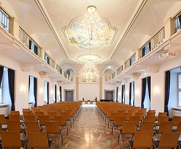 Gesamtansicht des Festsaals der Karlsburg in Durlach mit vielen Sitzplätzen und zwei großen Fensterfronten
