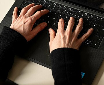 Hände tippen auf einer Tastatur