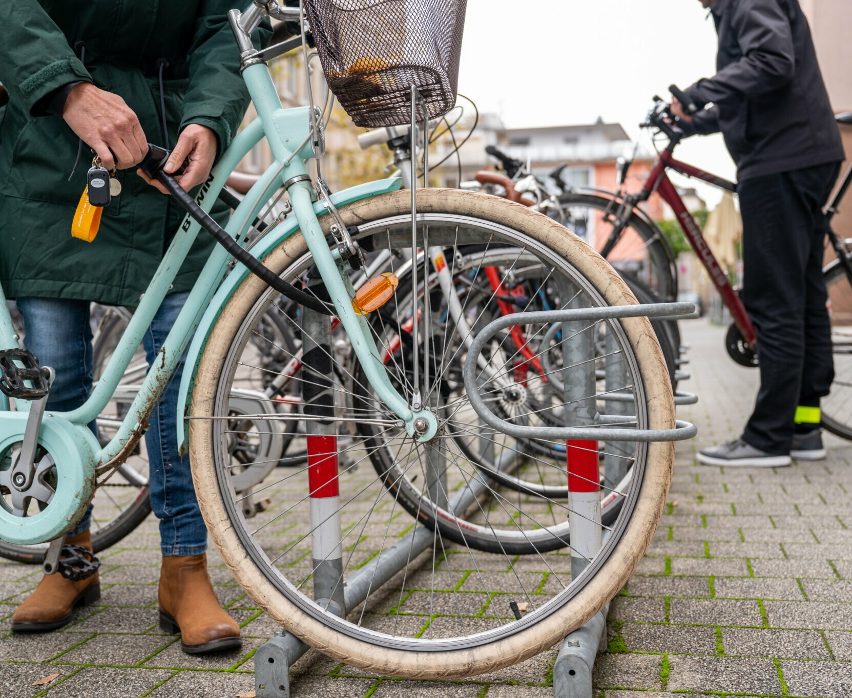 Zwei Personen stellen ihre Fahrräder am Fahrradständer in der Hebelstraße ab.
