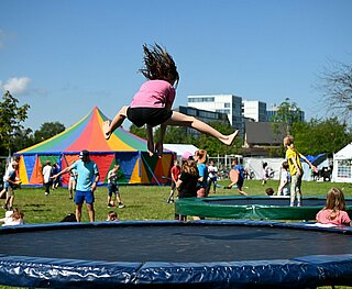 Ein Kind springt auf einem Trampolin auf dem Gelände des "Camps der 1000 Möglichkeiten".