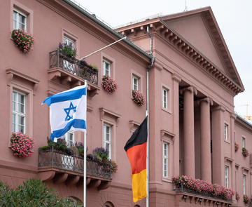 Deutsche und israelische Flagge auf halbmast gehisst vor dem Karlsruher Rathaus.