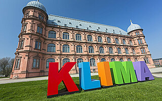 Für die Klimaaktionstage wurden große, plastische Buchstaben aus buntem Sperrholz angefertigt. Zusammengesetzt bilden sie das Wort "KLIMA". Hier stehen die Buchstaben vor dem Gottesauer Schloss.