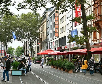 Menschen genießen bei einem Stadtbummel die Fußgängerzone in der Kaiserstraße von Karlsruhe