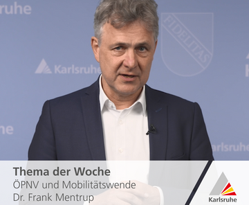 OB Frank Mentrup steht vor einem blauen Hintergrund und spricht zum Thema der Woche: ÖPNV und Mobilitätswende