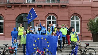 Menschen vor dem Rathaus mit Europafahne
