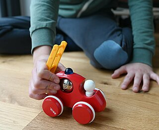 Kind spielt mit einem Spielzeugauto.