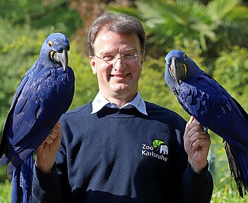 Dr. Reinschmidt mit zwei Papageien