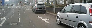 Das Bild zeigt ein falsch geparktes Auto. Tatbestand: Parken auf Fahrbahnen im Bereich von Richtungspfeilen und Leitlinien oder Fahrstreifenbegrenzungen