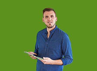 Mann mit Tablet in der Hand vor grünem Hintergrund