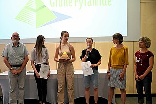 Schülerinnen,  Lehrkräfte des St. Dominikus Gymnasiums nehmen die Grüne Pyramide in der Kategorie "Naturschutz entgegen.
