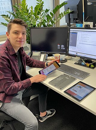 Junger Mann an einem PC-Arbeitsplatz