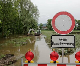 Eine Wiese an der Alb ist vom Hochwasser überflutet. Auf Hinweisschilder heißt es Einfahrt verboten wegen Hochwasser.