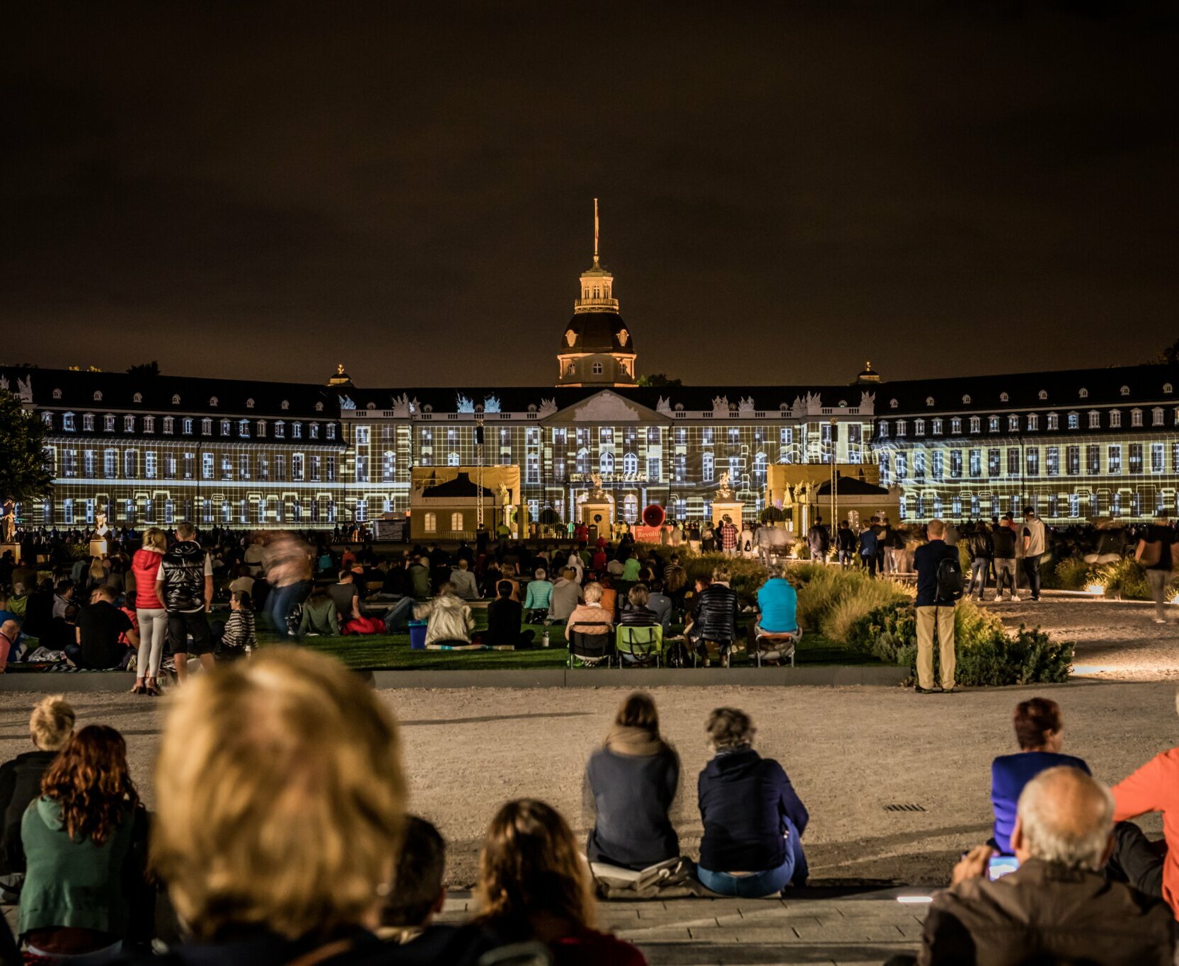 Das bunt angeleuchtete Schloss fasziniert das Publikum während der Karlsruhe Schlosslichtspiele.
