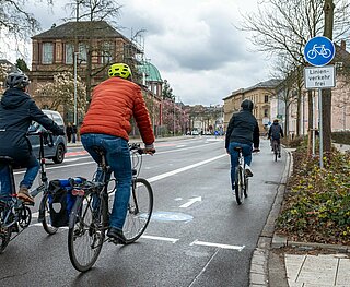 Personen auf Fahrrädern befahren Radstreifen in der Hans-Thoma-Straße.