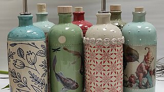 Das Bild zeigt bunte Flaschen aus Keramik im Retrodesign.