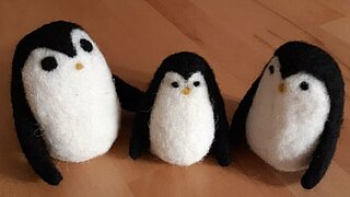 Das Bild zeigt drei Pinguine aus Filz.