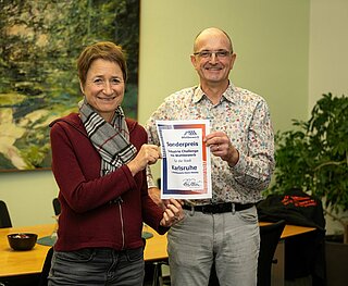 Rainer Romer von „Wattbewerb“ übergibt den Preis an Bürgermeisterin Bettina Lisbach.