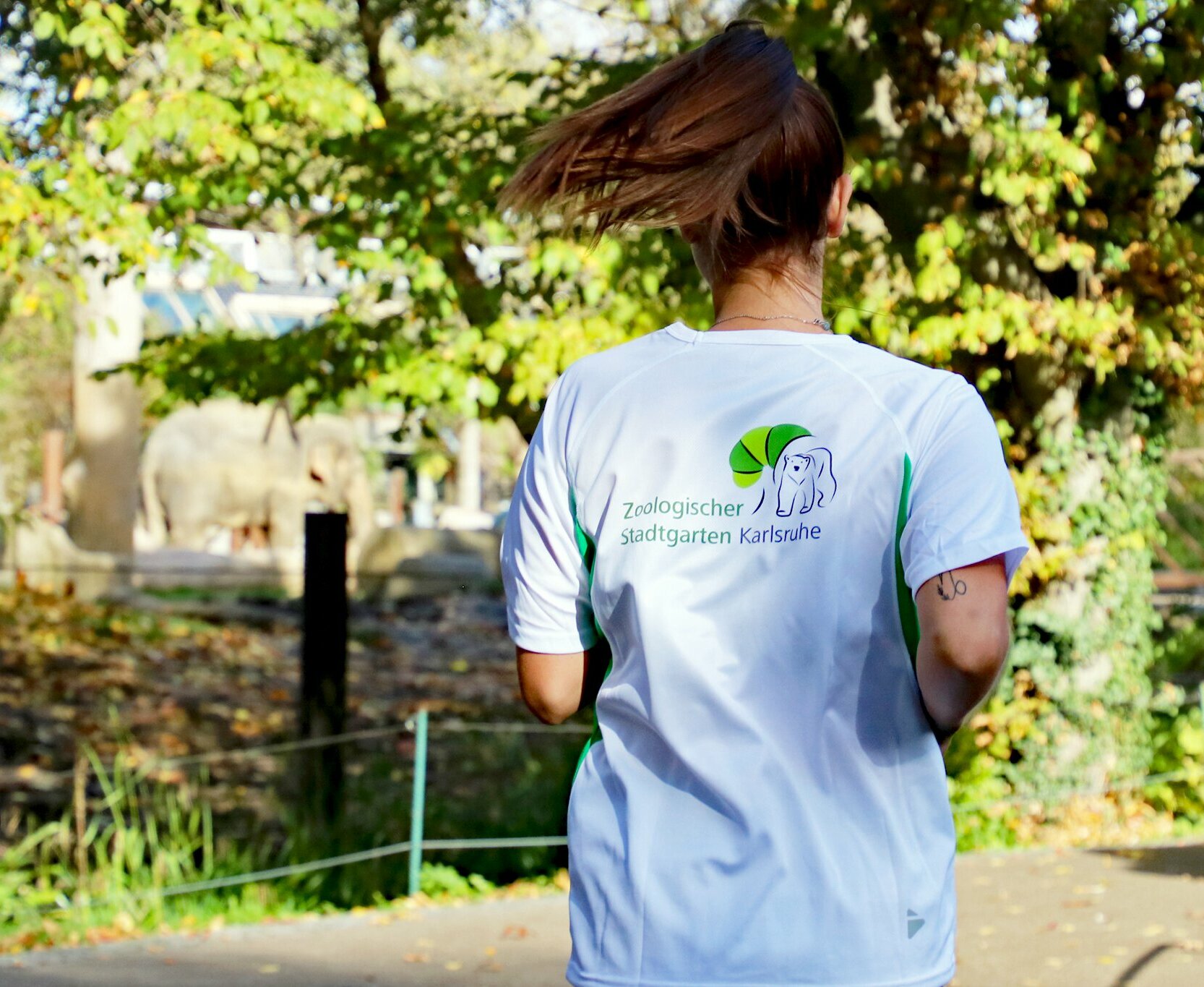 Eine Läuferin zeigt ihr T-Shirt mit der Aufschrift "Artenschutzlauf".