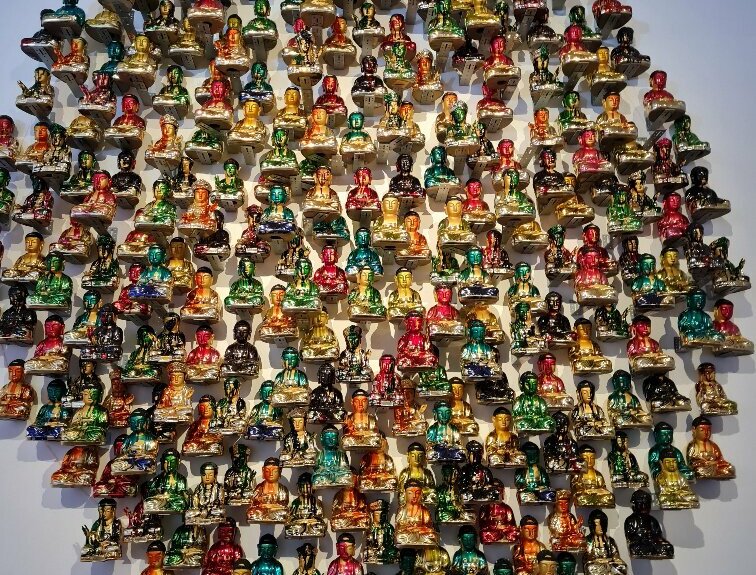 Kunstwerk mit bunten Buddha-Figuren aus Glas